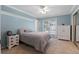 Bedroom with blue walls, ceiling fan, closet with mirrored doors, and sliding glass doors to the exterior at 103 Greenleaf Ln, Altamonte Springs, FL 32714