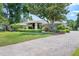 Lovely house with a well-manicured lawn, mature tree, stone accents, brick driveway and lush landscaping at 103 Greenleaf Ln, Altamonte Springs, FL 32714