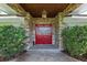 Elegant front entrance with stone columns, a warm lantern, and beautifully crafted red double doors at 103 Greenleaf Ln, Altamonte Springs, FL 32714
