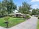 Beautiful home with a brick driveway, a lush green lawn, and well-maintained landscaping, complemented by mature trees at 103 Greenleaf Ln, Altamonte Springs, FL 32714