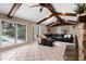 Bright living room with exposed beams, access to the lanai, and a stone fireplace at 103 Greenleaf Ln, Altamonte Springs, FL 32714