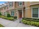 Charming exterior featuring a welcoming red door, lush landscaping, and well-maintained sidewalk at 1062 Winglewood, Altamonte Springs, FL 32714