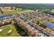 Aerial view of homes in a golf community with a pool and surrounding trees at 1082 Trappers Trail Loop, Davenport, FL 33896