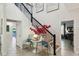 Elegant entryway featuring a staircase with a black iron railing, decorative floral arrangements, and stylish seating at 1082 Trappers Trail Loop, Davenport, FL 33896