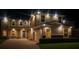 Stunning nighttime view of the home's exterior, highlighting its architectural features and outdoor lighting at 1082 Trappers Trail Loop, Davenport, FL 33896