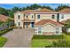 Beautiful two-story home featuring a tile roof, brick driveway and manicured lawn at 1082 Trappers Trail Loop, Davenport, FL 33896