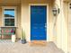 A welcoming front door with a blue finish, complemented by a bench, potted plants, and a 'Welcome' mat at 1082 Trappers Trail Loop, Davenport, FL 33896