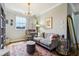 Stylish home office with hardwood floors, a comfortable couch and a well-lit desk at 1082 Trappers Trail Loop, Davenport, FL 33896