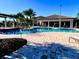 Community pool area with lounge chairs, lush landscaping, and covered seating at 1082 Trappers Trail Loop, Davenport, FL 33896