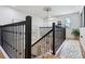 Elegant staircase with black wrought iron railings and a chandelier at 1082 Trappers Trail Loop, Davenport, FL 33896