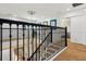 Bright and airy staircase featuring wood floors, black banister and a modern chandelier at 1082 Trappers Trail Loop, Davenport, FL 33896