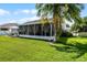 Lush backyard with covered patio, vibrant green lawn, mature palm tree, and black fenced perimeter at 1133 Brandy Lake View Cir, Winter Garden, FL 34787