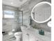 Modern bathroom with a glass shower, elegant vanity, and decorative round mirror at 1133 Brandy Lake View Cir, Winter Garden, FL 34787