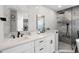 Modern bathroom featuring double vanity with black fixtures and walk-in shower with stylish gray tiling at 1133 Brandy Lake View Cir, Winter Garden, FL 34787