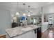 Island featuring granite countertop and sink opens to Living Room with a ceiling fan, TV, and a sliding glass door at 1133 Brandy Lake View Cir, Winter Garden, FL 34787