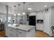Open-concept kitchen featuring white cabinets, stainless steel appliances, granite countertops, and a center island with a sink at 1133 Brandy Lake View Cir, Winter Garden, FL 34787