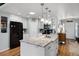 Open kitchen featuring a large island with sink, granite countertops, stainless steel appliances, and hardwood floors at 1133 Brandy Lake View Cir, Winter Garden, FL 34787