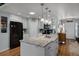 Bright kitchen with white cabinets, stainless steel appliances, center island with granite counters, sink, and hardwood floors at 1133 Brandy Lake View Cir, Winter Garden, FL 34787