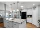 Bright kitchen featuring a large island with sink and granite countertops, black appliances, and hardwood floors at 1133 Brandy Lake View Cir, Winter Garden, FL 34787