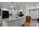 Bright kitchen featuring white cabinets, stainless steel appliances, center island with granite counters, sink, and hardwood floors at 1133 Brandy Lake View Cir, Winter Garden, FL 34787