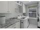 Well-organized laundry room featuring modern appliances, granite countertops, and ample storage for convenience at 1133 Brandy Lake View Cir, Winter Garden, FL 34787