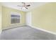 Bright bedroom features carpet floors, ceiling fan, and natural light from a window at 12832 Downstream Cir, Orlando, FL 32828