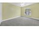This bedroom features gray carpet, green-painted walls, and a window providing natural light at 12832 Downstream Cir, Orlando, FL 32828