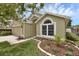 Home with lovely landscaping, mulch, and a stone border on a well-manicured lawn at 12832 Downstream Cir, Orlando, FL 32828