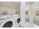 Convenient laundry area with a washer, dryer, and shelving for ample storage at 12832 Downstream Cir, Orlando, FL 32828