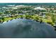 An aerial view features a lakeside community with lush greenery, private boat docks, and reflective lake surface at 13120 Zori Ln, Windermere, FL 34786