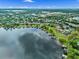 An aerial view shows a lakeside community with private boat docks, mature trees, and still waters reflecting the sky at 13120 Zori Ln, Windermere, FL 34786