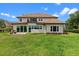 Beautiful back exterior and yard with large windows and patio seating at 13120 Zori Ln, Windermere, FL 34786