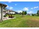 Expansive backyard features a stone patio with seating, leading to a well-manicured lawn and lake at 13120 Zori Ln, Windermere, FL 34786