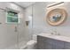 Modern bathroom with glass shower, vanity with sink, and decorative mirror at 13120 Zori Ln, Windermere, FL 34786