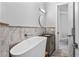 Bright bathroom features a modern soaking tub, vanity with dark countertop, and stone-look tile at 13120 Zori Ln, Windermere, FL 34786