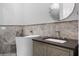 This bright bathroom has a modern soaking tub, a vanity with dark countertop, and stone-look tile at 13120 Zori Ln, Windermere, FL 34786