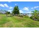 Scenic view of the lush green lawn leading to the wooden dock and boat house on the tranquil lake at 13120 Zori Ln, Windermere, FL 34786