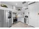 Modern white kitchen with stainless steel appliances and hardwood floors at 13120 Zori Ln, Windermere, FL 34786