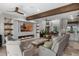 Open-concept living room with fireplace, tile floors, beam ceiling, and views of the dining room and kitchen at 13120 Zori Ln, Windermere, FL 34786