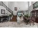 Elegant living room with high ceilings, staircase, piano, and dining room with lake view at 13120 Zori Ln, Windermere, FL 34786
