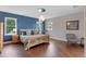 Bright main bedroom with a blue accent wall, hardwood floors, and decorative light fixture at 13120 Zori Ln, Windermere, FL 34786