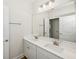 Bathroom featuring double sinks, a large mirror, and white cabinets at 13123 Faro Ct # 23, Winter Garden, FL 34787