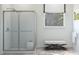 Modern bathroom with glass-enclosed shower and a white accent bench at 13123 Faro Ct # 23, Winter Garden, FL 34787