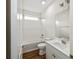 Bright, white bathroom with tub and shower combination, white subway tile, and wood-look flooring at 13123 Faro Ct # 23, Winter Garden, FL 34787