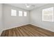 Bright bedroom features wood-look floors, a modern ceiling fan and three windows at 13123 Faro Ct # 23, Winter Garden, FL 34787