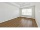Bedroom featuring wood-look floors, paneled accent wall, and a bright window at 13123 Faro Ct # 23, Winter Garden, FL 34787