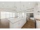 Spacious kitchen and living area featuring a large island, stainless steel appliances, and a seamless open-concept design at 13123 Faro Ct # 23, Winter Garden, FL 34787