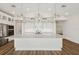 Modern kitchen with sleek white cabinetry, stainless steel appliances, pendant lighting, and an oversized island at 13123 Faro Ct # 23, Winter Garden, FL 34787