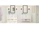 Bright bathroom with dual white vanities, framed mirrors, and decorative sconces at 13181 Telsen St # 39, Winter Garden, FL 34787