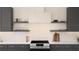 Modern kitchen featuring stainless steel appliances, gray cabinets, open shelving, and stylish white backsplash at 13181 Telsen St # 39, Winter Garden, FL 34787